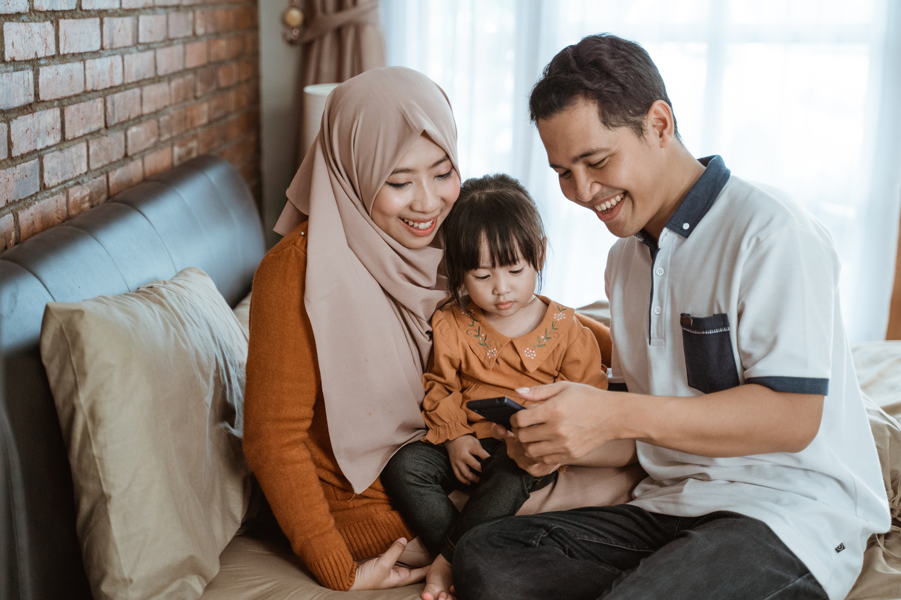 Happiness of a Muslim Family Together When Using a Smartphone